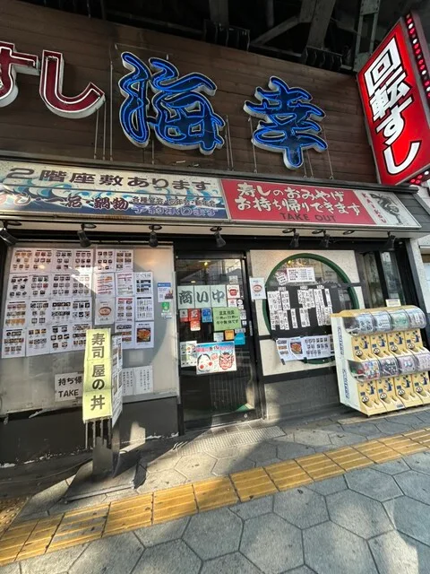 카이텐 스시 카이코우의 큰 상호 간판과 메뉴 안내가 있는 매장 외관