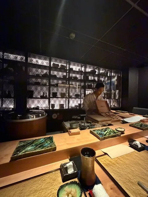 스시 Shizuku의 나무 카운터와 조리 공간이 보이는 매장 내부