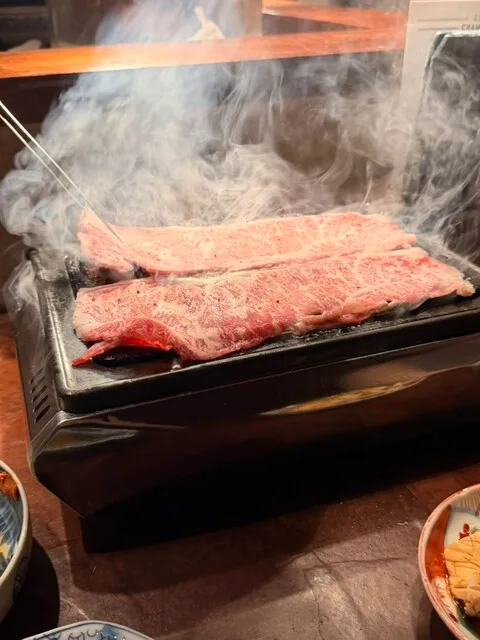 야키니쿠야 KEIZO의 연기가 피어오르는 불판 위의 길쭉한 소고기