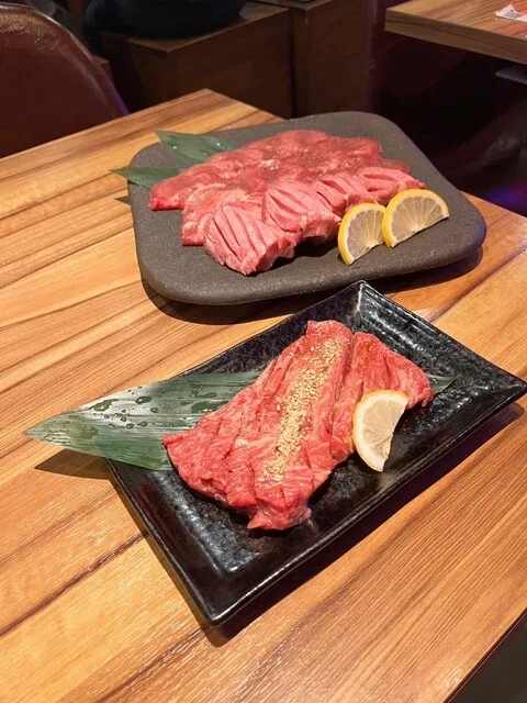 와규 야키니쿠 다베호우다이 야키니쿠갱 우메다점의 검은 접시 두 개에 담긴 상갈비와 우설 모듬