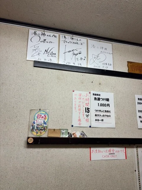라쿠니진의 서명 액자와 메뉴 안내가 붙은 실내 벽