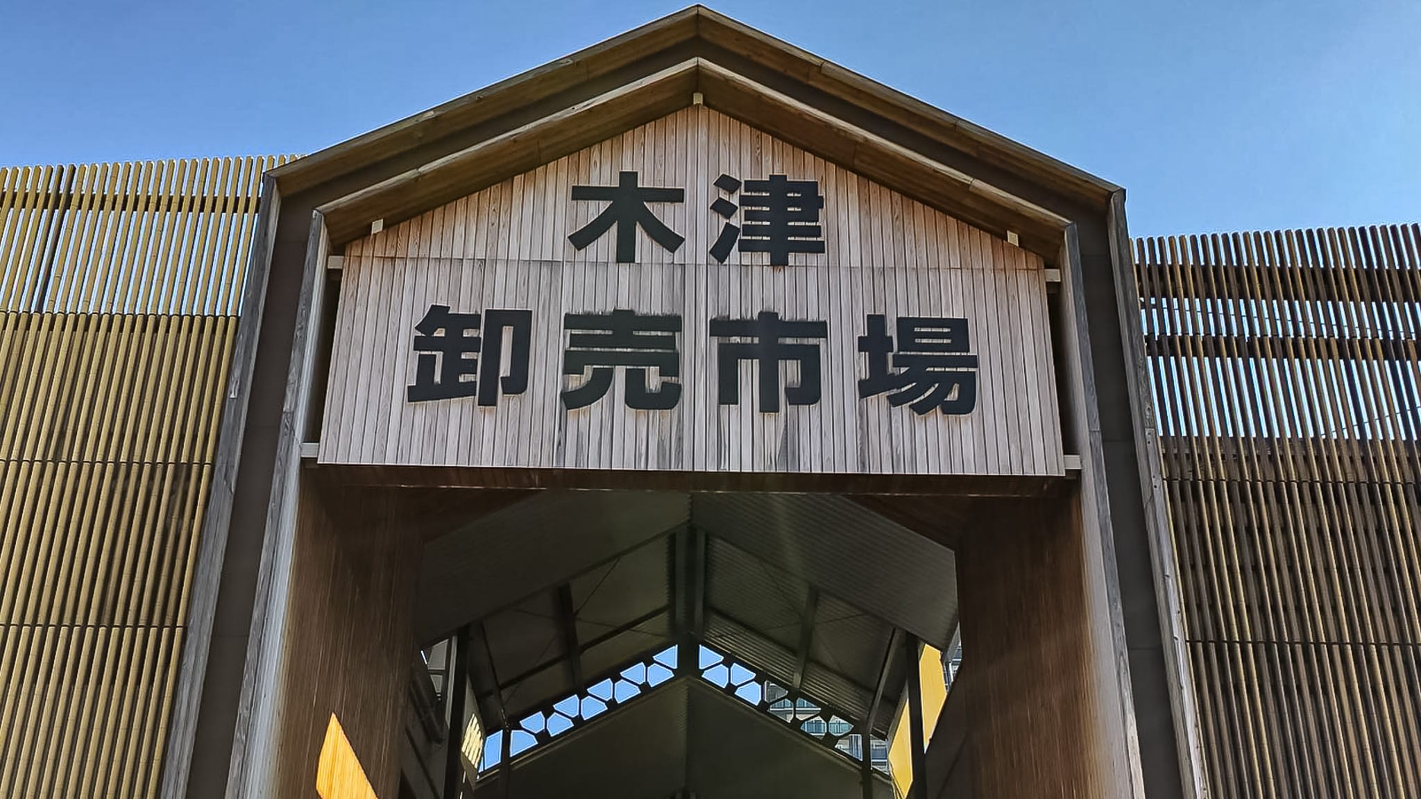 대나무로 외벽이 장식되어 있고 나무 판자 위에 간판을 그린 오사카 기즈 도매시장의 입구